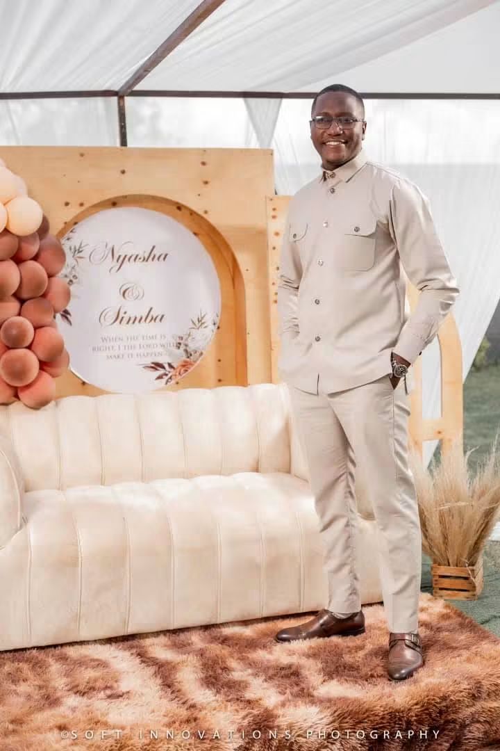 Simba in a cream two-piece beside the Nyasha and Simba signage