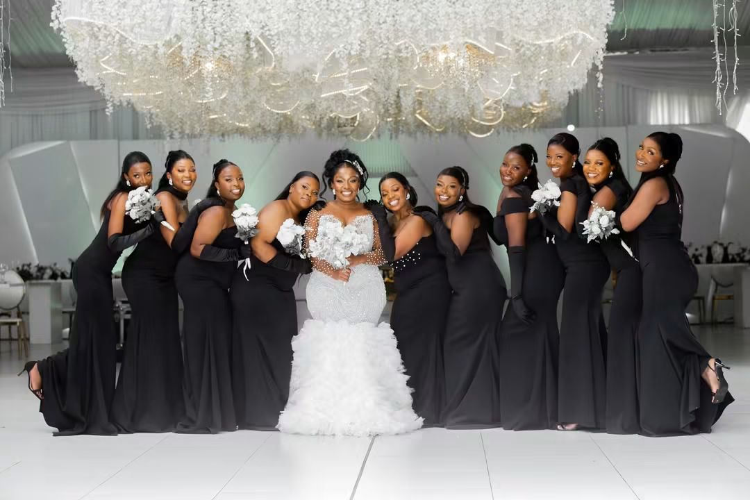 Nyasha surrounded by her bridesmaids holding white bouquets