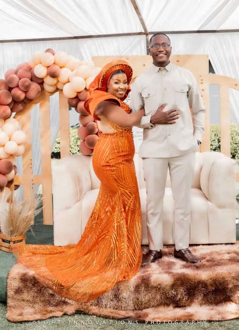 Nyasha in a beaded orange gown and matching headwrap at her roora