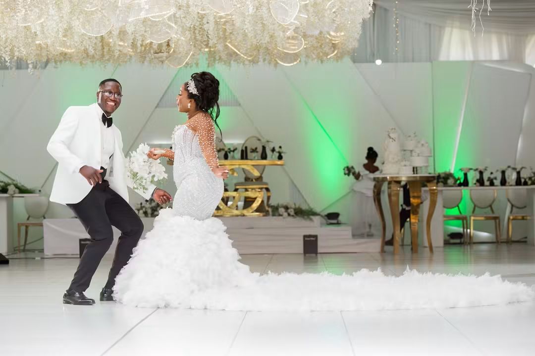 Simba and Nyasha dancing on the white dance floor beneath a floral chandelier